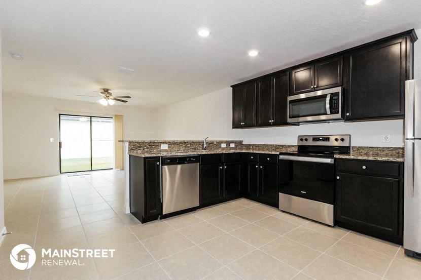 a kitchen with black cabinets and stainless steel appliances