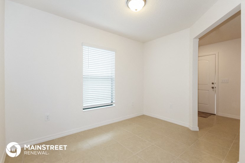 the spacious living room with a door to the hallway