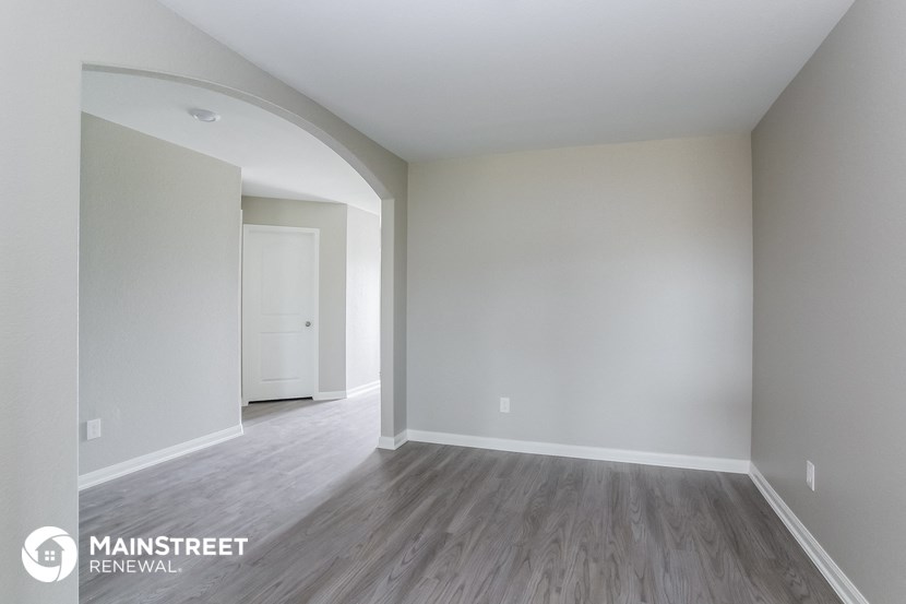 a living room with white walls and wood floors