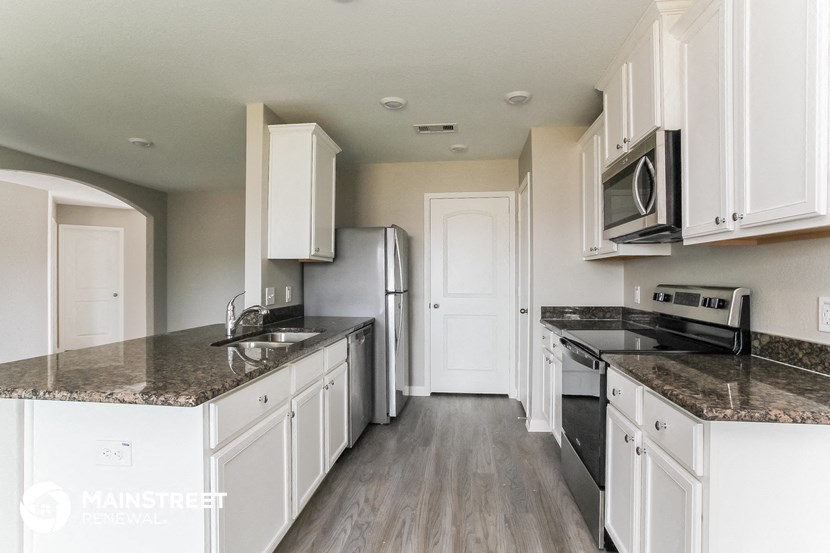 a kitchen with white cabinets and granite counter tops