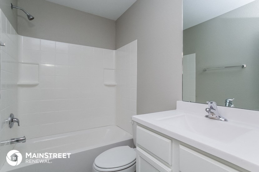 a white bathroom with a sink and a tub and a toilet
