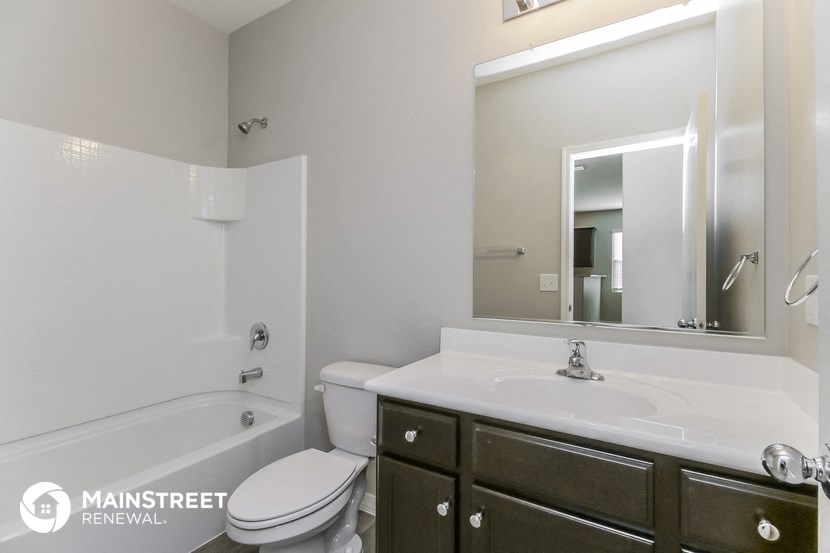 a bathroom with a sink toilet and mirror and a tub