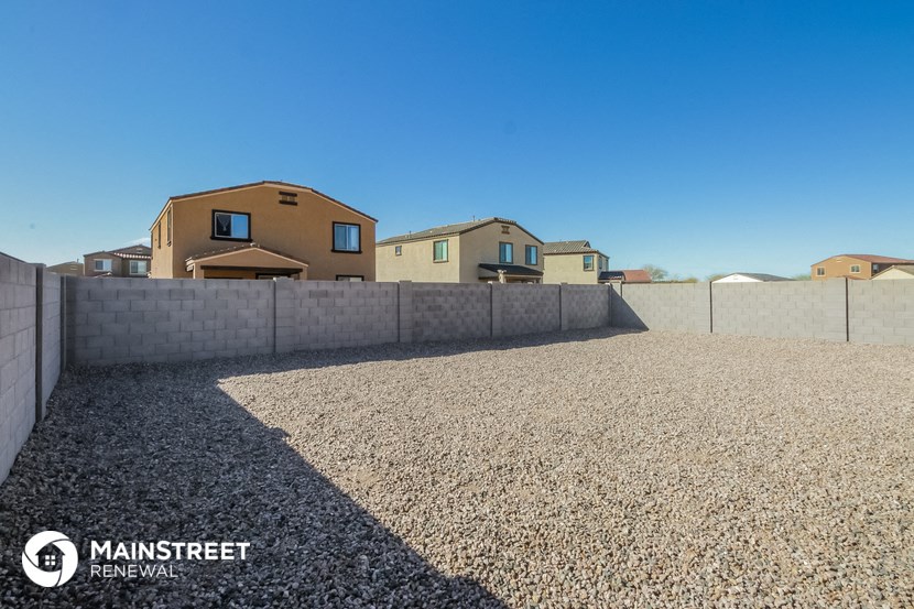 a gravel driveway in front of a row of houses