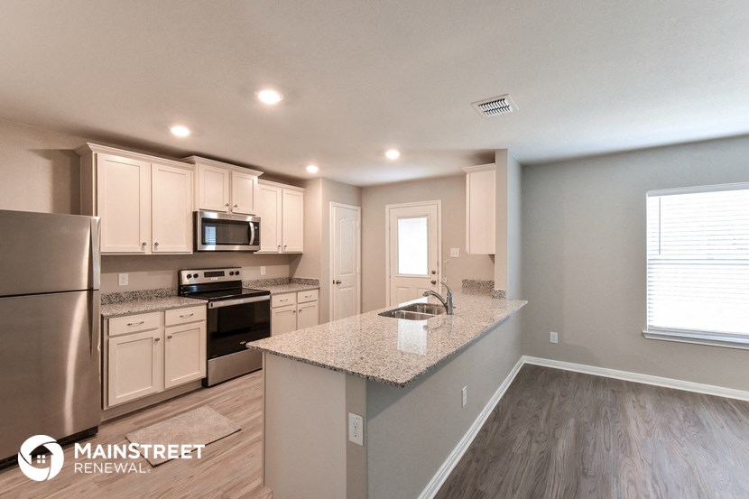 the kitchen with granite countertops and stainless steel appliances