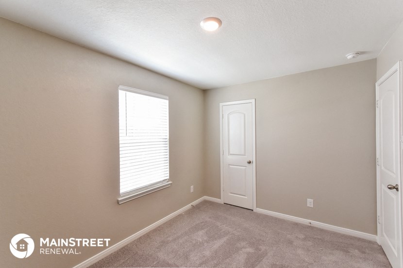 the upstairs bedroom has a carpeted floor and a window