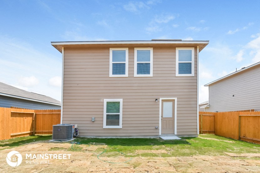 the exterior of a house with a wooden fence and a yard