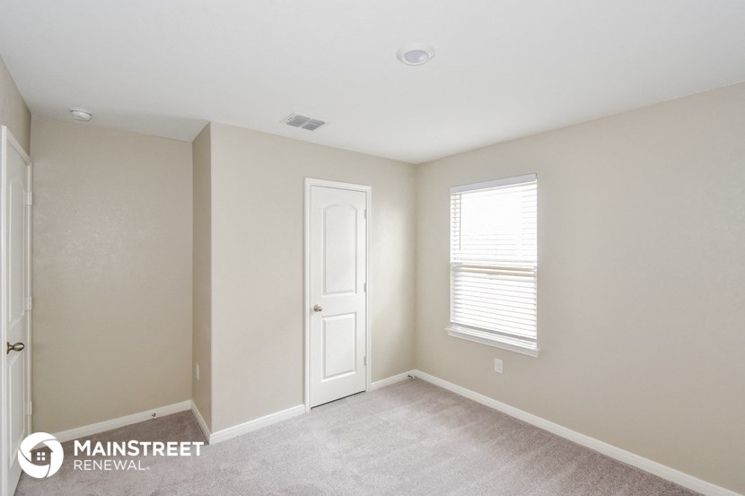 a bedroom with a white door and a window