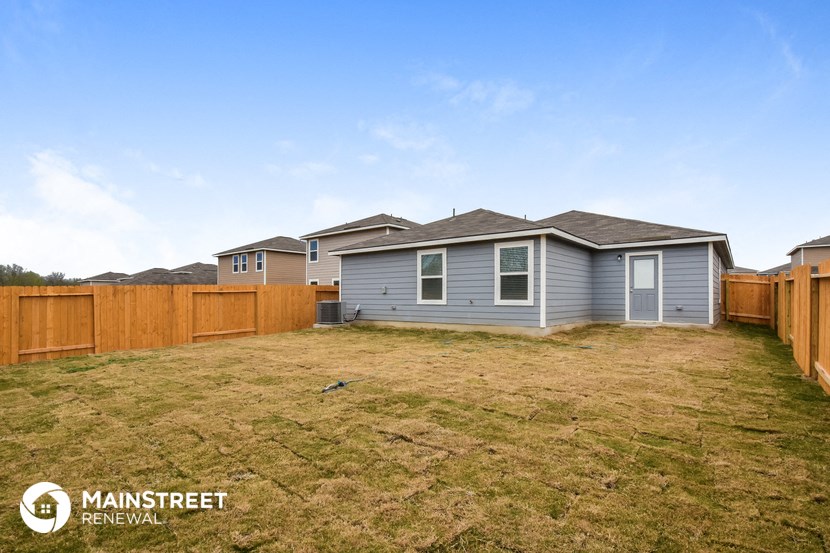 a blue house with a yard and a wooden fence