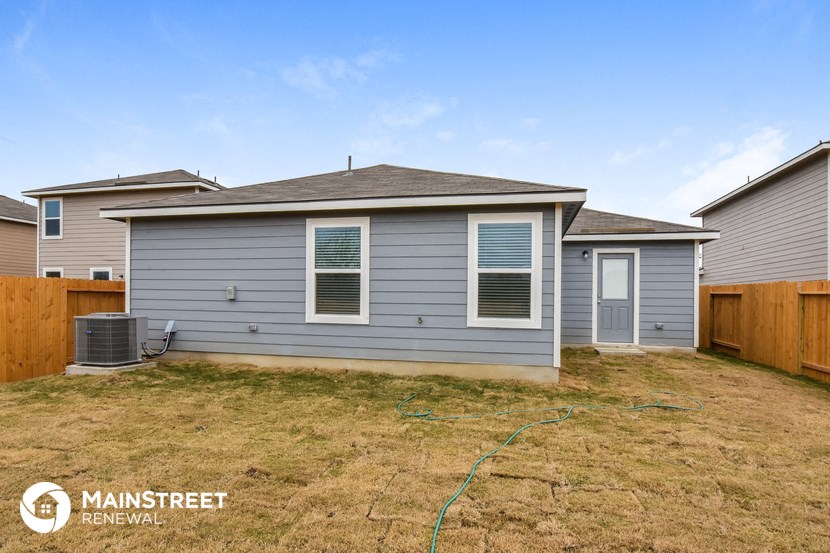 a blue house with a backyard and a wooden fence