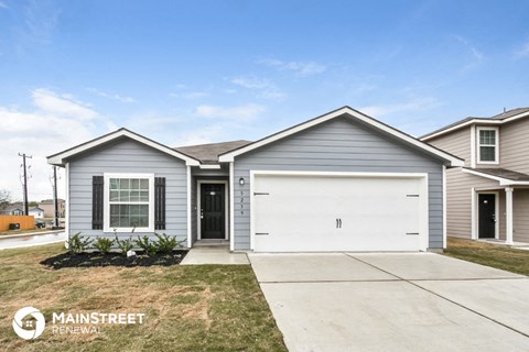 a blue house with a white garage door and a lawn