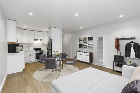 A modern kitchen with white cabinets and a dining table with chairs.