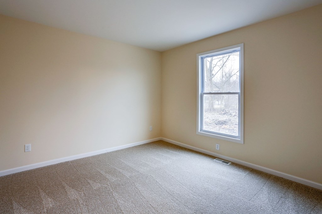 an empty room with carpet and a window