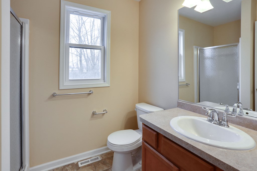 a bathroom with a sink toilet and a mirror