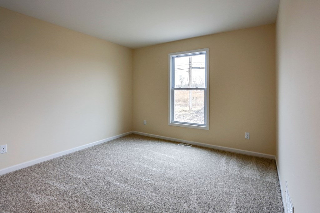 an empty room with carpet and a window