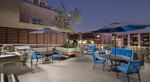 A patio with blue chairs and tables is set up for dining.