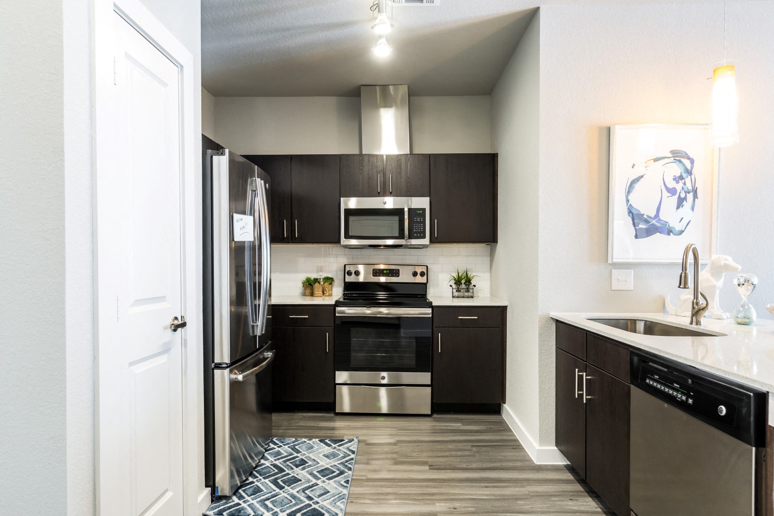 Kitchen with island, farm-style sink, wood-plank flooring, and pantry