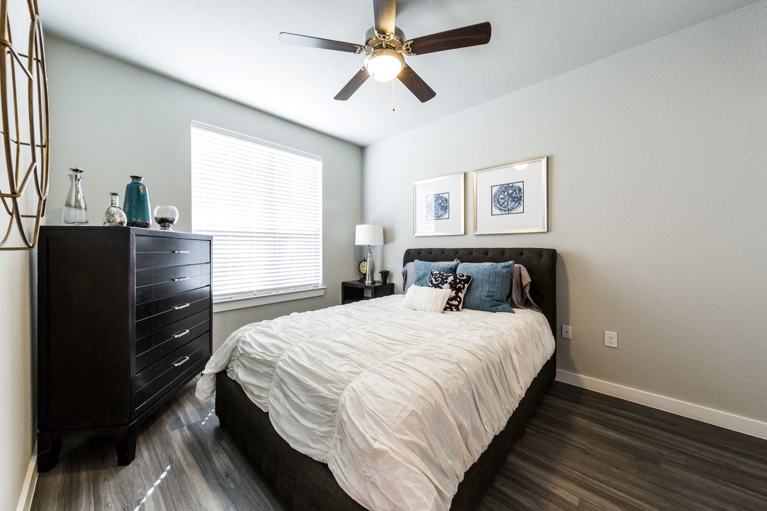 Bedroom one with wood-style flooring, ceiling fan and large bedside window