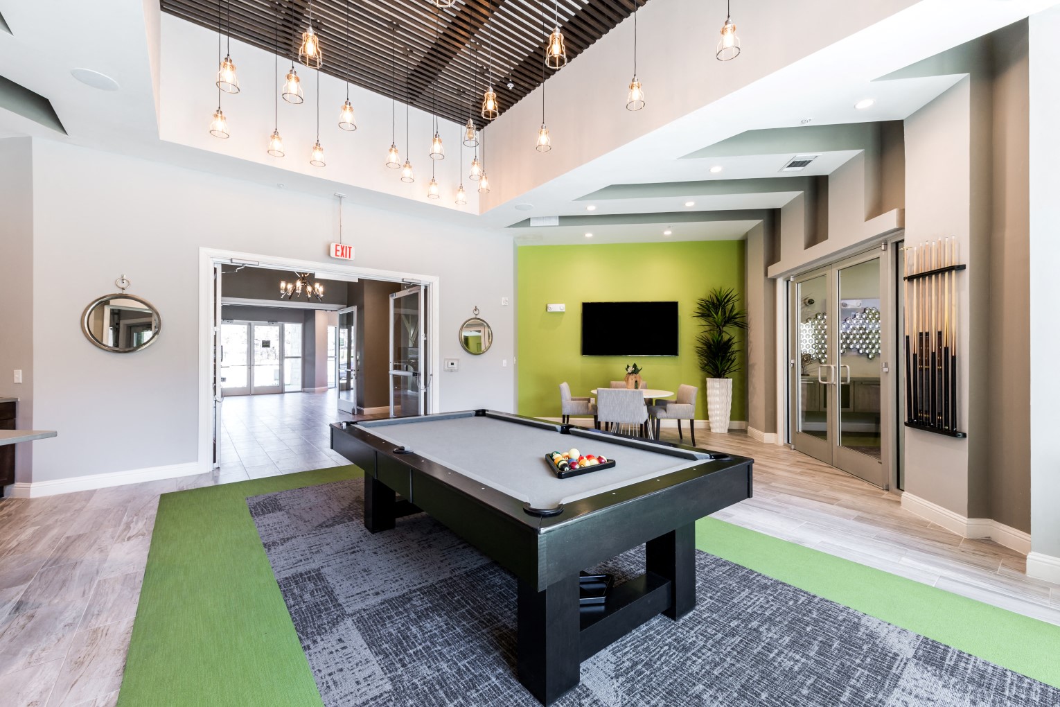 Game lounge with modern light fixture and seating area with cable TV