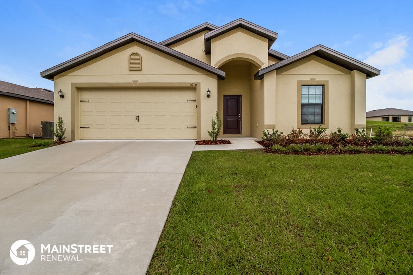 a beige house with a driveway and a garage door