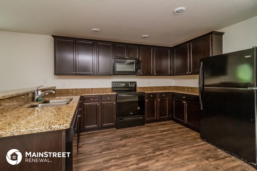 a kitchen with dark wood cabinets and granite counter tops