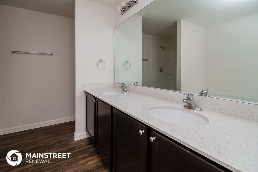 a bathroom with two sinks and a large mirror