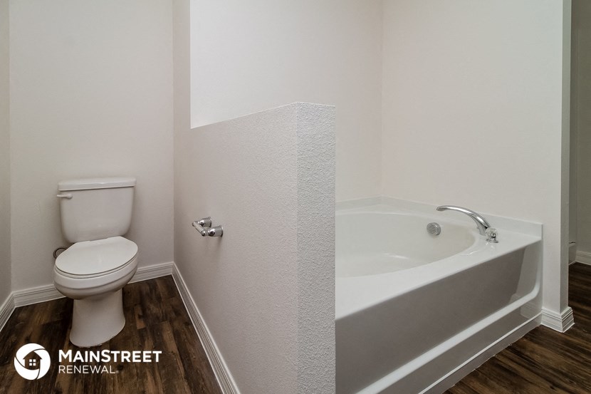 a bathroom with a toilet and a bath tub