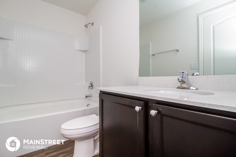 a bathroom with a sink toilet and tub and a mirror
