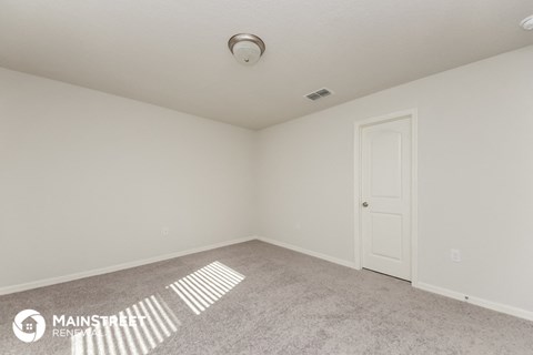 a room with a white door and a carpeted floor