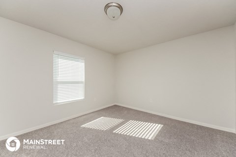 the upstairs bedroom with carpet and window
