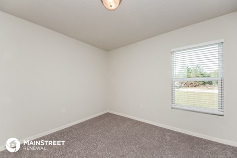 the upstairs bedroom with carpeted flooring and a window