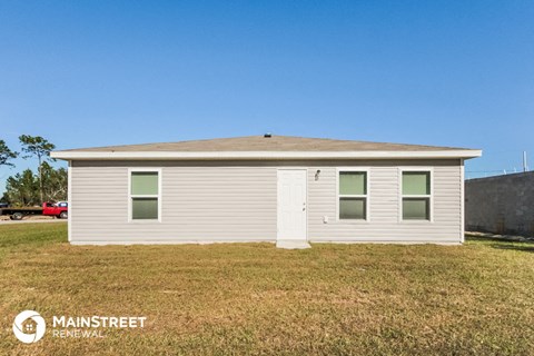 a small white house with a lawn in front of it