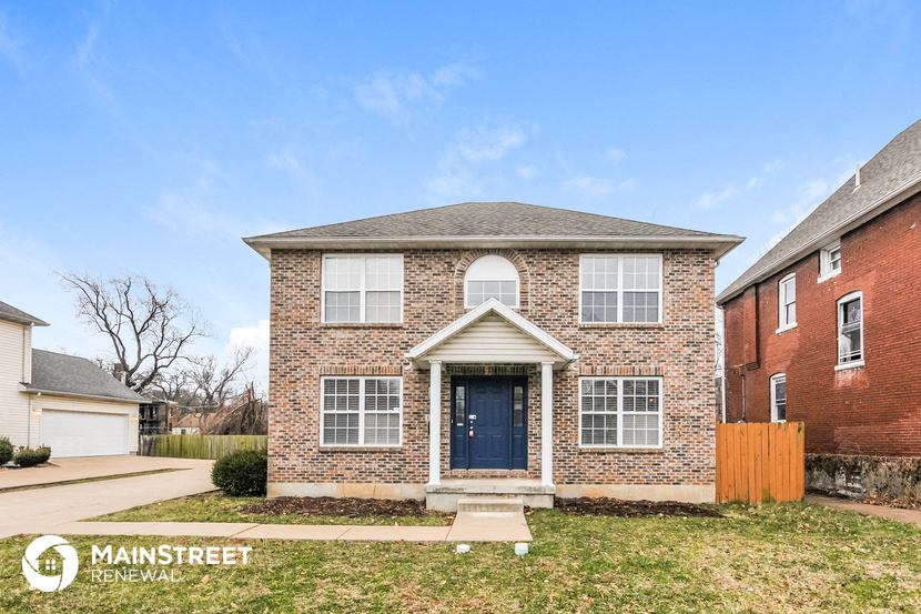 the front view of a brick house with a blue door