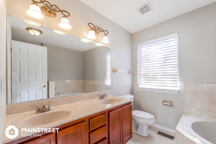 two sinks and a toilet in a bathroom with a large mirror
