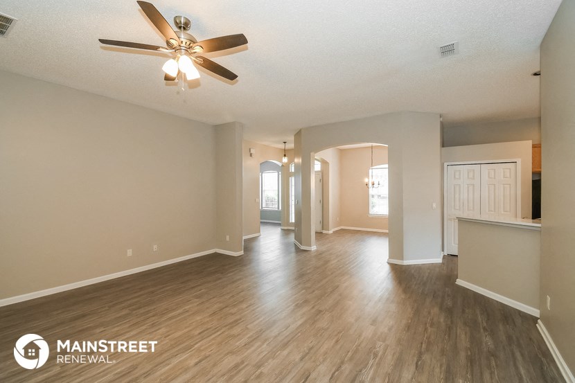 the living room and dining room with hardwood flooring and a ceiling fan