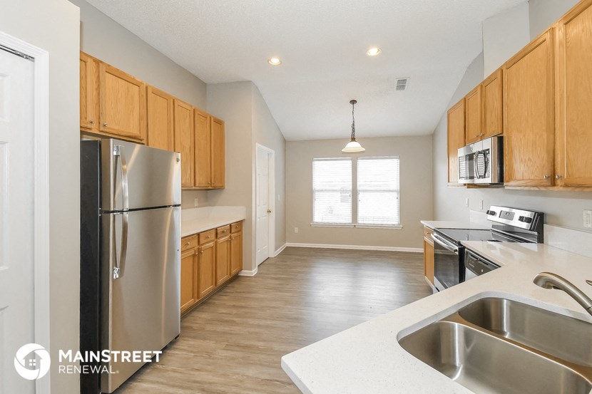 a kitchen with wooden cabinets and stainless steel appliances