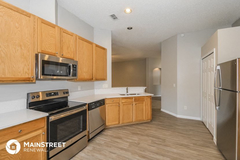 a kitchen with wooden cabinets and stainless steel appliances