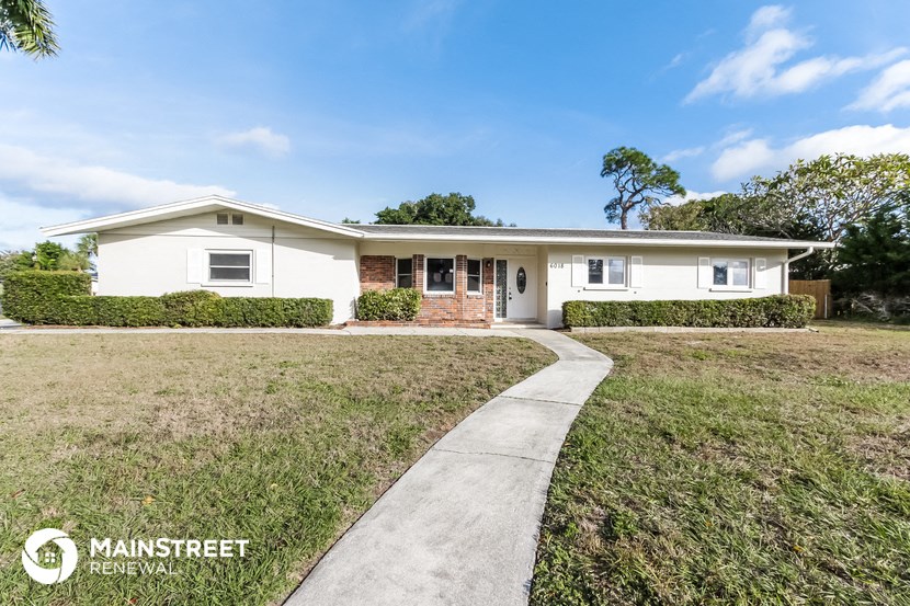a white house with a sidewalk in front of it