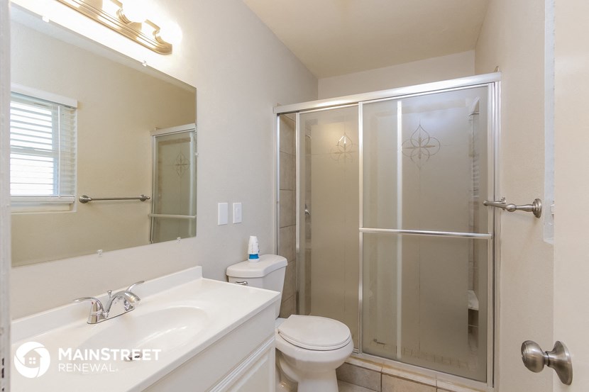 a bathroom with a shower and a sink and a toilet