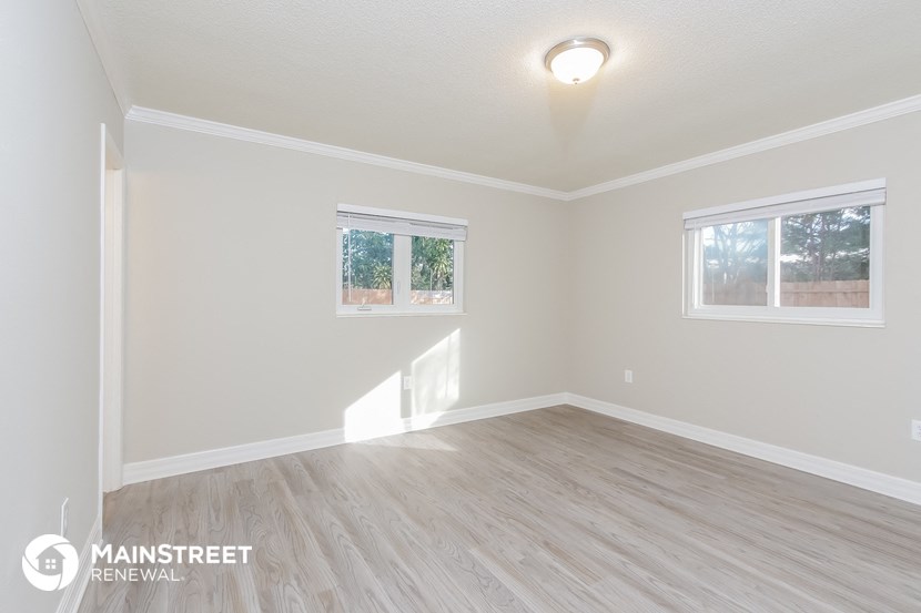 the upstairs living room after remodeling with wood floors and white walls