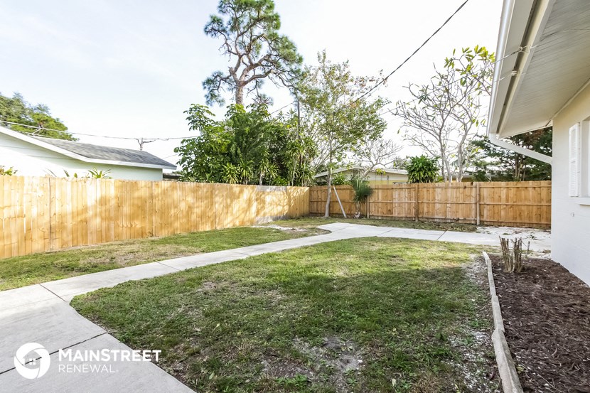 a fenced in backyard with a wooden fence and grass