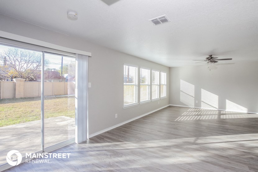 an empty living room with a sliding glass door to a patio