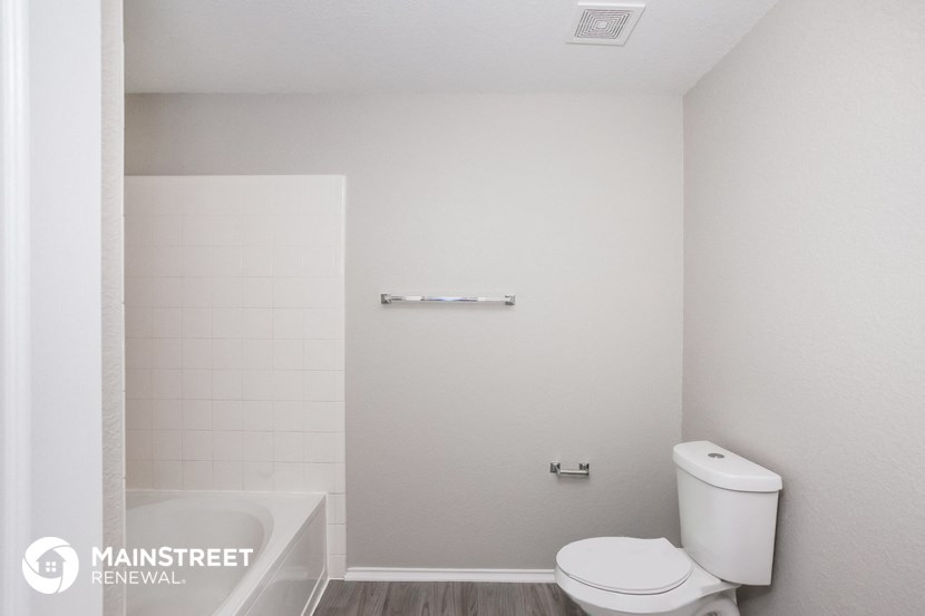 a small bathroom with a toilet and a tub and a shower