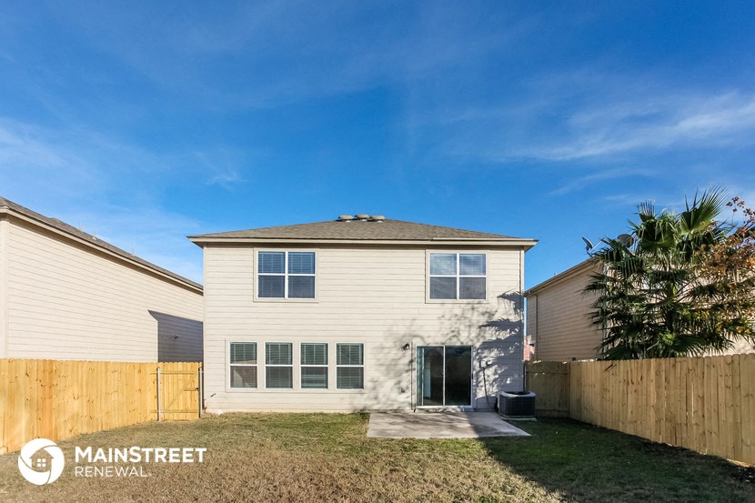 a small white house with a backyard and a fence