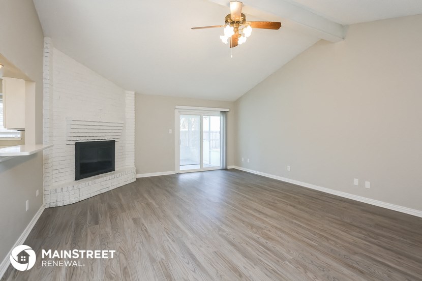 a living room with a fireplace and a ceiling fan