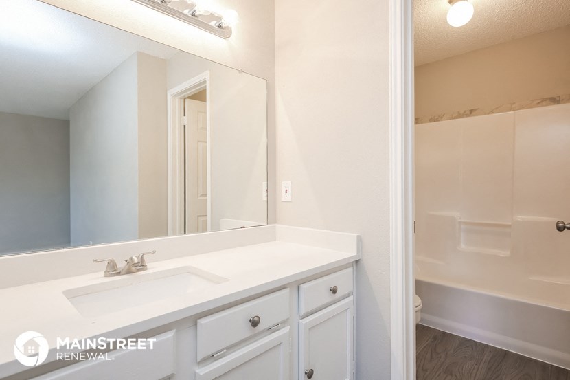 a white bathroom with a sink and a mirror