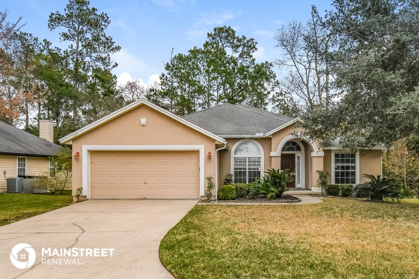 a beige house with a driveway and a garage door