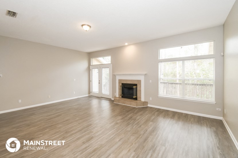 the living room with wood flooring and a fireplace