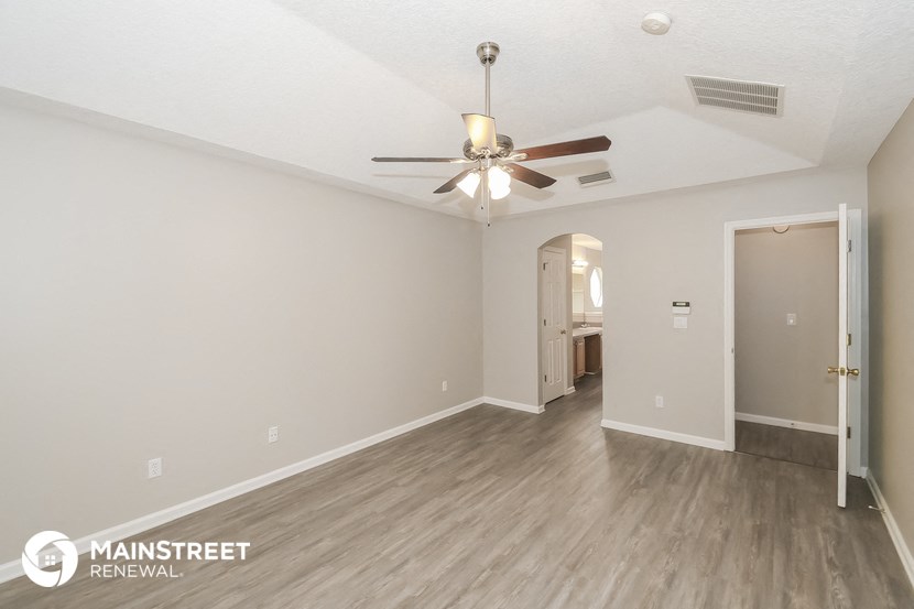 the spacious living room with ceiling fan and hardwood flooring