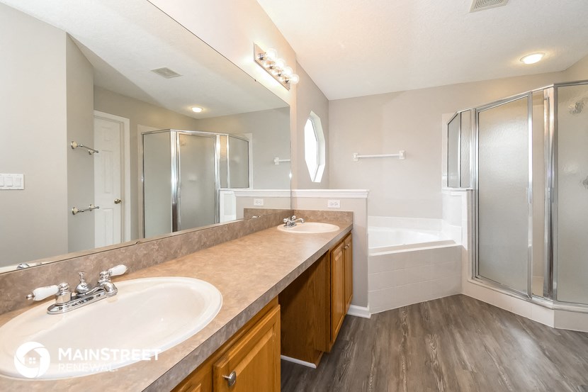 a bathroom with a sink and a shower and a mirror