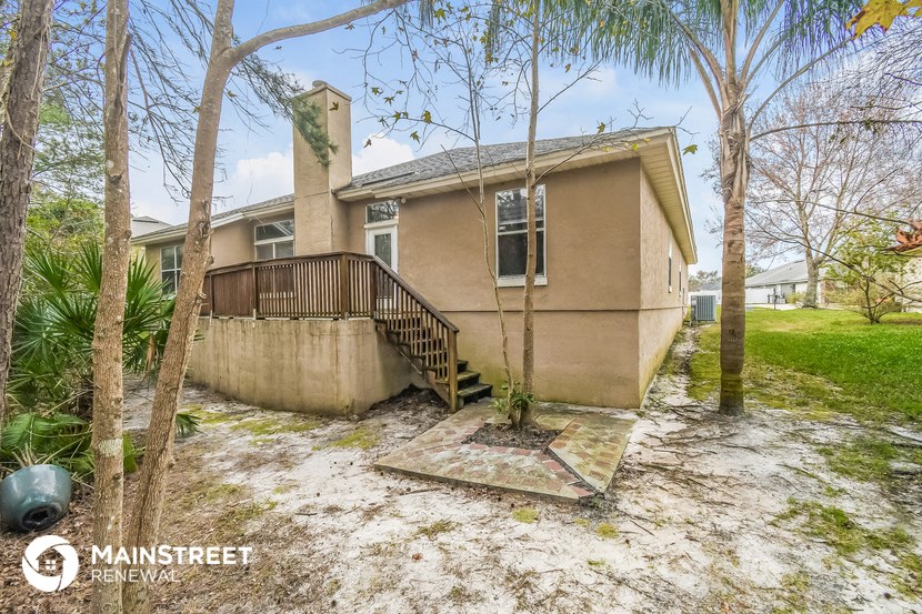 the front of a house with trees and a staircase